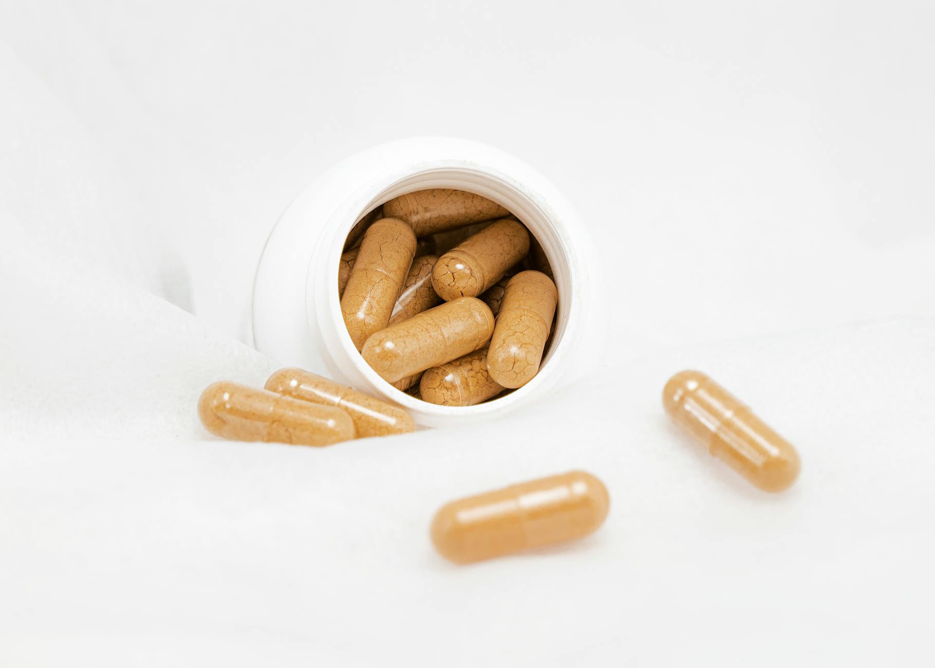 Magnesium glycinate capsules next to a glass of water on nightstand